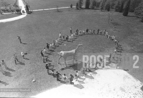 BELLUNO 1975 VILLA FULCIS GIROTONDO ATTORNO AL MARCOCAVALLO © ARCHIVIO Graziano Arici/Rosebud2  MARCOCAVALLO SCULTURA DI VITTORIO BASAGLIA, FRANCO BASAGLIA E PAZIENTI OSPEDALE PSICHIATRICO TRIESTE GIROTONDO ESTERNO VILLA FULCIS
