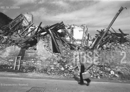 GEMONA 1976 CASA DISTRUTTA DOPO IL TERREMOTO NEL FRIULI CON PERSONA CHE CI PASSA DAVANTI © ARCHIVIO Graziano Arici/Rosebud2  TERREMOTO FRIULI VENEZIA GIULIA CATASTROFI AMBIENTALI CASE DISTRUTTE ROVINE MACERIE