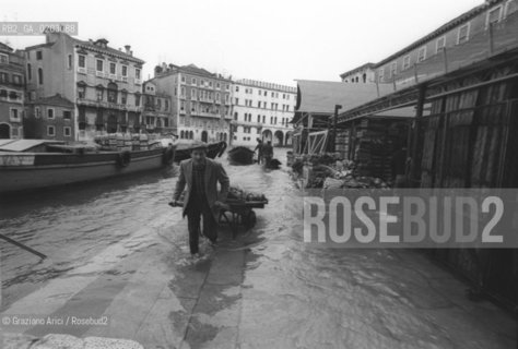VENEZIA 1976 UOMO CHE PORTA UN CARRETTO NELLACQUA ALTA © ARCHIVIO Graziano Arici/Rosebud2  ACQUA ALTA CALLE MERCATO CARRETTO PROBLEMI VENEZIA