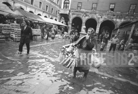 VENEZIA 1976 ACQUA ALTA AL MERCATO DI RIALTO © ARCHIVIO Graziano Arici/Rosebud2  ACQUA ALTA CALLE MERCATO DONNA CON CESTE PROBLEMI VENEZIA