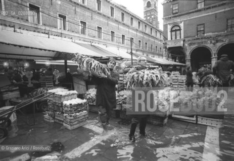 VENEZIA 1976 UOMINI CHE LAVORANO AL MERCATO NELLACQUA ALTA © ARCHIVIO Graziano Arici/Rosebud2  ACQUA ALTA PROBLEMI VENEZIA MERCATO RIALTO LAVORATORI CASSE VERDURA