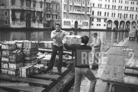 VENEZIA 1977 LAVORATORI CHE SCARICANO CASSE DI VERDURA © ARCHIVIO Graziano Arici/Rosebud2  EX MERCATO ORTOFRUTTICOLO RIALTO BARCA CASSETTE VERDURA LAVORATORI
