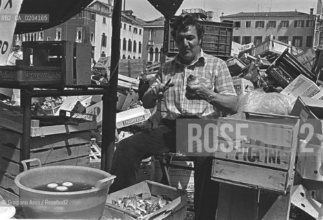 VENEZIA 1978 VENDITORE DI VERDURA CHE PULISCE CARCIOFI © ARCHIVIO Graziano Arici/Rosebud2  MERCATO VERDURA ORTOFRUTTICOLO IN BARCONE PULITURA CARCIOFI