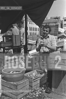VENEZIA 1978 VENDITORE DI VERDURA CHE PULISCE CARCIOFI © ARCHIVIO Graziano Arici/Rosebud2  MERCATO VERDURA ORTOFRUTTICOLO IN BARCONE PULITURA CARCIOFI