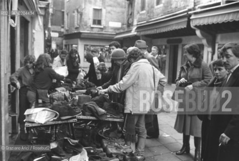 VENEZIA 1979 VENDITA SCARPE DOPO ACQUA ALTA © ARCHIVIO Graziano Arici/Rosebud2  ALTA MAREA CAMPO SAN STIN BAMBINI PROBLEMI DISAGI VENEZIA BANCERELLE  SCARPE