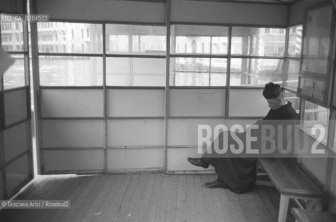 VENEZIA 1980 PRETE ADDORMENTATO CHE ASPETTA IL VAPORETTO © ARCHIVIO Graziano Arici/Rosebud2  PRETE IMBARCADERO ACTV