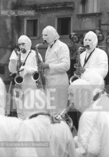 MESTRE 1981 MUSICISTI JAZZ CON MASCHERE E TUTE BIANCHE © ARCHIVIO Graziano Arici/Rosebud2  MANIFESTAZIONE MUSICA URBAN SAX PIAZZA FERRETTO AUTOBUS JAZZ FOLLA INQUINAMENTO ECOLOGIA