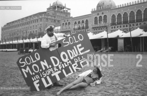 VENEZIA 1981  UOMO E RAGAZZA CON CARTELLONE FILM AL LIDO © ARCHIVIO Graziano Arici/Rosebud2  BIENNALE 81 CINEMA LIDO SPIAGGIA HOTEL EXCELSIOR CARTELLONE MONDO DUE