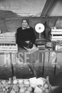 VENEZIA 1981 DONNA AL MERCATO CON ACQUA ALTA © ARCHIVIO Graziano Arici/Rosebud2  ALTA MAREA MERCATO RIALTO PROBLEMI DISAGI VENEZIA