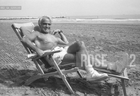 VENEZIA 1982 PRESIDENTE MPAA IN SEDIA A SDRAIO © ARCHIVIO Graziano Arici/Rosebud2  BIENNALE CINEMA 82 SPIAGGIA LIDO VENEZIA