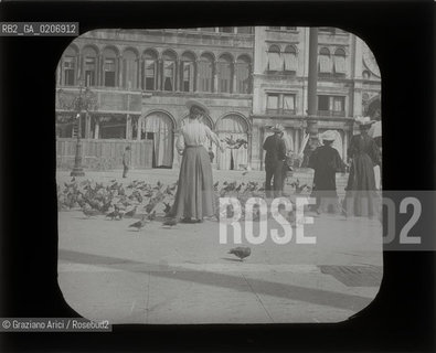 -VENEZIA, SENZA INDICAZIONE DAUTORE, DONNA CON PICCIONI IN PIAZZA S. MARCO, SENZA DATA. LASTRA IN VETRO PER LANTERNA MAGICA CONTENUTE DENTRO LA LORO ORIGINALE CUSTODIA 10,1X8,2 ©ARCHIVIO Graziano Arici/Rosebud2   FOTOANTICHE.-VENICE, NO AUTHORS INDICATION,  DONNA CON PICCIONI IN PIAZZA S. MARCO, UNDATED. GLASS SLIDE FOR MAGIC LANTERN IN THEIR WOODEN ORIGINAL BOX, CM 10,1X8,2 ©Graziano Arici/Rosebud2 