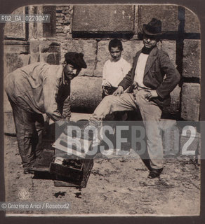 Naples, fine  1800?. Lustrascarpe al lavoro. Shoe-shine boy into the street. RITRATTO LUSTRASCARPE - La cessione dei diritti si intende per quanto di nostra competenza; non comprende invece le eventuali spese relative a diritti che potranno essere richiesti dagli Enti cui appartengono le opere riprese. Tali costi, ove neccessari, e l’espletamento di qualsivoglia pratica di richiesta permessi sono esclusivamente  a  carico del committente. © ARCHIVIO Graziano Arici/Rosebud2 