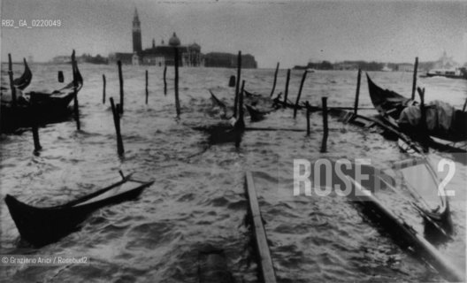 Venice,1966. Disastrosa alluvione, veduta del bacino di San Marco con gondole distrutte e rovesciate. Acqua alta, alta marea, inondazione, gondola, bacino, San Marco. High tide and torrential rains: flood waters in Venice. Gondola; Bacino; alluvione; alta marea - La cessione dei diritti si intende per quanto di nostra competenza; non comprende invece le eventuali spese relative a diritti che potranno essere richiesti dagli Enti cui appartengono le opere riprese. Tali costi, ove neccessari, e l’espletamento di qualsivoglia pratica di richiesta permessi sono esclusivamente  a  carico del committente. © ARCHIVIO Graziano Arici/Rosebud2 