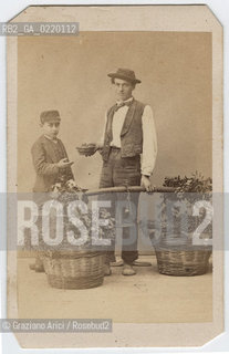 -VENEZIA, SENZA INDICAZIONE DELLAUTORE, RITRATTO POSATO IN STUDIO DI VENDITORE DI NOCCIOLE MENTRE PORGE UN CESTELLO AD UN BAMBINO,1867?. STAMPA ALLALBUMINA INCOLLATA SU CARTONE, CARTE DE VISITE, CM 6,5X10,5. FOTOANTICHE, POSATO, RITRATTO, VENDITORE .-VENICE, NO AUTHORS INDICATION,PORTRAIT OF NUT VENDER,1867?. ALBUMEN PHOTOGRAPH MOUNTED ON CARDBOARD, CARTE DE VISITE CM 6,5X10,5 © ARCHIVIO Graziano Arici/Rosebud2 .