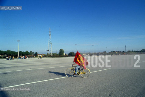 - Portomarghera, Venezia,1995.Operai del settore chimico in sciopero.Operaio in bicicletta con bandiera.POLITICA manifestazione Sciopero lavoro operai autostrada bandiera bici.- Portomarghera, Venice,1995.Strike of the Workers of the chemical sector.Worker with flag  ©Graziano Arici/Rosebud2