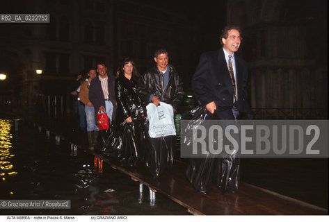 Nome:..ALTA MAREA..HIGHT TIDE..Localizzazione:..VENEZIA / S. MARCO / PIAZZA S. MARCO..VENICE / ST. MARK  / ST. MARK S SQUARE..Soggetto:..PERSONE USANO SACCHETTI PER POTEGGERSI E CAMMINANO SOPRA LE PASSERELLE IN PIAZZA S. MARCO DI NOTTE DURANTE L ACQUA ALTA..PERSONS ARE USEING A SACK LIKE PROTECTION AND WALKING ON THE WALKWAY IN THE NIGHT IN S. MARK S SQUARE DURING THE HIGHT TIDE..Cronologia:......Autore:......Stile:......Editori Stampatori:......Committenza:......Materia e Tecnica:......Collocazione:......Note:....Riproduzione Fotografica:..Graziano Arici/Rosebud2 ...Copyright:..Graziano Arici / rosebud2/....Data:..1995....Costo:..A....Key:..ACQUA ALTA..HIGHT TIDE..
