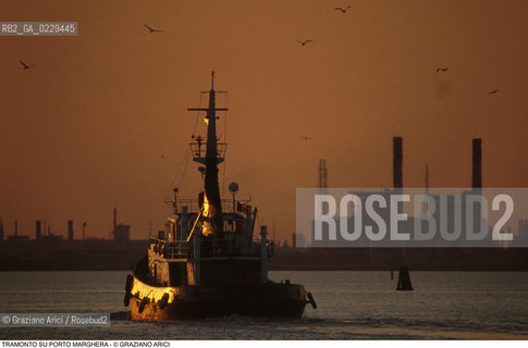 Caption: Localizzazione:..PORTO MARGHERA..Oggetto:..Soggetto:..ZONA INDUSTRIALE FABBRICHE CIMINIERE TRAMONTO RIMORCHIATORE LAGUNA..Cronologia: ....Definizione Culturale:..   Autore:....   Stile:..   Editori/Stampatori:..   Committenza:..Materia e Tecnica:....Collocazione:..Note:..PORTO MARGHERA..Riproduzione Fotografica:..Copyright:..Graziano Arici/Rosebud2 .Data:..1990..Costo:..A