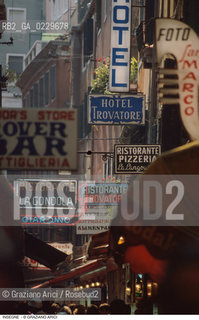 Caption: Localizzazione:..VENEZIA / CASTELLO..Oggetto:..Soggetto:..INSEGNE TURISTICHE IN CALLE DELLE RAZZE / NEON..Cronologia: ..Definizione Culturale:..   Autore: ..   Stile: ..   Editori/Stampatori:..   Committenza:..Materia e Tecnica:..Collocazione:..Note:..TURISMO DEGRADO URBANO..Riproduzione Fotografica:..Copyright:..Graziano Arici/Rosebud2 .Data:..1994..Costo:..A