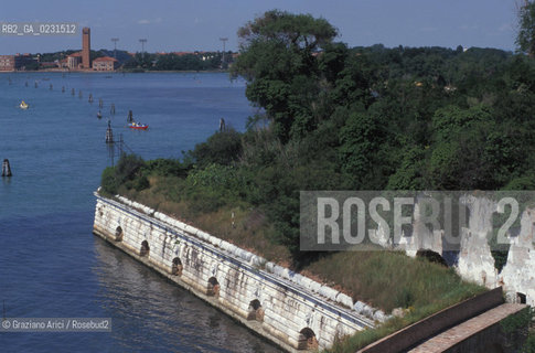 Caption: Nome:..ISOLA DI SANTANDREA: IL FORTE....Localizzazione:..VENEZIA / ISOLA DI SANTANDREA  / LAGUNA NORD..VENICE / THE ISLE OF SANTANDREA / THE NORTH LAGOON..Soggetto:..ISOLA DI SANTANDREA / IL FORTE / MURO DI CINTA / SULLO SFONDO SANT ELENA, VENEZIA..THE ISLE OF SANTANDREA / THE FORT / THE BOUNDARY WALL  / IN THE BACKGROUND SANT ELENA, VENICE..Cronologia:..SEC. XVI SECONDO QUARTO / 1543..XVIth CENTURY / 1543..Autore:..MICHELE SANMICHIELI (1484-1559)....Stile:......Editori Stampatori:......Committenza:..SIGNORIA DI VENEZIA CON DECRETO DEL 23 DICEMBRE 1534..SIGNORIA OF VENICE WITH DECREE OF 23 DECEMBER 1534..Materia e Tecnica:..STRUTTURA IN MATTONI RIVESTITA IN PIETRA DISTRIA..BRICK STRUCTURE COVERED  WITH ISTRIAN STONE..Collocazione:......Note:..LISOLA OSPITA LE CASERME DEL REGGIMENTO LAGUNARI SERENISSIMA / QUI VI FU PREPARATO IL VOLO SU VIENNA DI GABRIELE DANNUNZIO IL 9 AGOSTO DEL 1918..THE ISLAND IS THE SEAT OF THE LAGUNARI SERENISSIMA REGIMENT / HERE, GABRIELE DANNUNZIO ORGANISED THE FLIGHT TO VIENNA ON 9 AUGUST 1918 ..Riproduzione Fotografica:..Graziano Arici/Rosebud2 ...Copyright:..Graziano Arici / rosebud2/....Data:..1998....Costo:..A....Key:..ISOLE ABBANDONATE..UNINHABITED ISLANDS