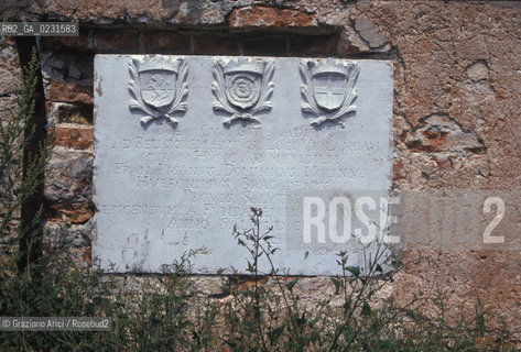 Caption: Nome:..ISOLA DI SANTARIANO....Localizzazione:..VENEZIA / ISOLA DI SANTARIANO / LAGUNA NORD..VENICE / THE ISLE OF SANTARIANO   / THE NORTH LAGOON..Soggetto:..ISOLA DI SANTARIANO / LAPIDE SUL MURO DI CINTA ..THE ISLE OF SANTARIANO / PLAQUE ON THE BOUNDARY WALL ..Cronologia:..SEC. XVIII INIZIO / 1705..XVIIIth CENTURY..Autore:......Stile:......Editori Stampatori:......Committenza:......Materia e Tecnica:......Collocazione:......Note:..NEL 1565 VIENE REALIZZATO UN MURO CHE RECINGE ANCORA OGGI LA PARTE DELLISOLA ALLORA DESTINATA AD OSSARIO / LAPIDE CON TRE STEMMI RICORDA LANNO 1705 IN CUI LA RECINZIONE MURARIA FU TERMINATA..IN 1565 A WALL HAS BEEN BUILT TO SURROUND AN OSSUARY / PLAQUE WITH THREE ARMS PLACED AFTER THE BOUNDARY WALL WAS BUILT IN 1705..Riproduzione Fotografica:..Graziano Arici/Rosebud2 ...Copyright:..Graziano Arici / rosebud2/....Data:..1993....Costo:..A....Key:..ISOLE ABBANDONATE..UNINHABITED ISLANDS