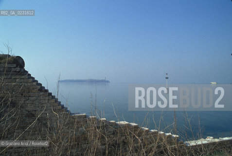 Caption: Nome:..ISOLA DI SAN CLEMENTE: MURO DI CINTA....Localizzazione:..VENEZIA / ISOLA DI SAN CLEMENTE / LAGUNA SUD..VENICE / THE ISLE OF SAN CLEMENTE / THE SOUTH LAGOON..Soggetto:..ISOLA DI SAN CLEMENTE / MURO DI CINTA..ISLE OF SAN CLEMENTE / BOUNDARY WALL..Cronologia:......Autore:......Stile:......Editori Stampatori:......Committenza:......Materia e Tecnica:......Collocazione:......Note:..I PRIMI EDIFICI RISALGONO AL XII SECOLO / DAL 1834 LISOLA DIVENNE MANICOMIO PROVINCIALE FEMMINILE FINO AL1992 / SACCHEGGIATA NEL 1992, OGGI E DIVENTATA RIFUGIO PER GATTI RANDAGI, GRAZIE AI VOLONTARI DELLASSOCIAZIONE DINGO..THE FIRST BUILDINGS  DATE BACK TO THE XII CENTURY  / FROM 1834 TO 1992 IT WAS USED AS A GIRLS MENTAL HOSPITAL  / SACKED IN 1992, IT BECAME A REFUGE FOR STRAY CATS, THANKS TO  VOLUNTARY DINGO ASSOCIATION..Riproduzione Fotografica:..Graziano Arici/Rosebud2 ...Copyright:..Graziano Arici / rosebud2/....Data:..1993....Costo:..A....Key:..ISOLE ABBANDONATE..UNINHABITED ISLANDS
