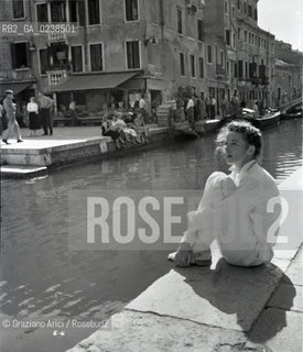 -Venezia,1955. Riprese del film Tempo destate di David Lean con Katharine Hepburn. Lattrice Katharine Hepburn seduta vicino al canale, lungo le fondamenta di San Barnaba. Cinema film riprese scena Venezia attrice ritratto.-Venice,1955. Shooting of the film Summertime by David Lean, with Katharine Hepburn. Portrait of the actress Katharine Hepburn near the canal of Campo San Barnaba - Archivio Graziano Arici.Avvertenze relative al copyright delle immagini.Le immagini riprodotte sono state eseguite per promuovere il prodotto culturale di cui in didascalia..La possibilità di utilizzare queste immagini è riservata unicamente al fine di corredare con le stesse, servizi, articoli, segnalazioni inerenti liniziativa cui si riferiscono. .La cessione dei diritti di questa immagine si intende per quanto di nostra competenza. Non comprende invece le eventuali spese  relative a diritti che potranno essere richiesti dagli Enti o persone fisiche cui appartengono eventualmente i soggetti  ripresi. Tali costi, ove necessari, e l’espletamento di qualsivoglia pratica di richiesta di concessione del permesso di pubblicazione sono esclusivamente a carico e a cura del soggetto acquirente di questa immagine...  astga ©Graziano Arici/Rosebud2