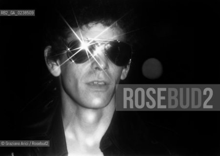 -Fine anni 70. Ritratto del cantautore e chitarrista rock Lou Reed, con occhiali da sole. Musica cantante cantautore chitarrista rock ritratto occhiali.-Late 70. Portrait of the singer and guitarist Lou Reed, with the sunglasses - Archivio Graziano Arici..Avvertenze relative al copyright delle immagini.Le immagini riprodotte sono state eseguite per promuovere il prodotto culturale di cui in didascalia..La possibilità di utilizzare queste immagini è riservata unicamente al fine di corredare con le stesse, servizi, articoli, segnalazioni inerenti liniziativa cui si riferiscono. .La cessione dei diritti di questa immagine si intende per quanto di nostra competenza. Non comprende invece le eventuali spese  relative a diritti che potranno essere richiesti dagli Enti o persone fisiche cui appartengono eventualmente i soggetti  ripresi. Tali costi, ove necessari, e l’espletamento di qualsivoglia pratica di richiesta di concessione del permesso di pubblicazione sono esclusivamente a carico e a cura del soggetto acquirente di questa immagine..