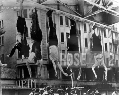 -Milano, 29 aprile 1945. Piazzale Loreto.Esposizione dei cadaveri del Duce Benito Mussolini (secondo da sinistra) e di Claretta Petacci  dopo la fucilazione esposti presso un distributore a Piazzale Loreto, insieme ad altri gerarchi fascisti. Politica Fascismo Guerra cadavere Duce fascista gerarca dittatore morte appeso.-Milan, 29 april 1945.Piazzale Loreto. Exposition of the Ducès, Benito Mussolini, and of his partners, Claretta Petacci, cadavers in the Piazzale Loreto, after the execution, with others fascist hierarchs - Archivio Graziano Arici..LArchivio Arici non è riuscito ad avere informazioni sullautore di questa foto. Siamo comunque a disposizione di qualunque avente diritto per riconoscere eventuali proprietà intellettuali che non sia stato possibile fin qui attribuire. .Qualora si fosse inavvertitamente leso qualsiasi diritto di riproduzione, si prega di contattare lArchivio che provvederà a rimuovere le immagini in questione..La cessione dei diritti di questa immagine si intende per quanto di nostra competenza. Non comprende invece le eventuali spese  relative a diritti che potranno essere richiesti dagli Enti o persone fisiche cui appartengono eventualmente i soggetti  ripresi. Tali costi, ove necessari, e l’espletamento di qualsivoglia pratica di richiesta di concessione del permesso di pubblicazione sono esclusivamente a carico e a cura del soggetto acquirente di questa immagine.  astga ©Graziano Arici/Rosebud2