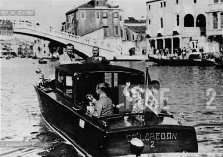 -Venezia,1937.Il Duca di Windsor Edoardo VIII in viaggio di nozze a Venezia con la moglie Wallis Simpson in taxi in Canal Grande. Duca Nobile Windsor nozze.-Venice,1937. The Duke of Windsor Edward VIII with his wife Wallis Simpson during the honeymoon in Venice © Archivio Graziano Arici .LArchivio Arici non è riuscito ad avere informazioni sullautore di questa foto. Siamo comunque a disposizione di qualunque avente diritto per riconoscere eventuali proprietà intellettuali che non sia stato possibile fin qui attribuire. .Qualora si fosse inavvertitamente leso qualsiasi diritto di riproduzione, si prega di contattare lArchivio che provvederà a rimuovere le immagini in questione..La cessione dei diritti di questa immagine si intende per quanto di nostra competenza. Non comprende invece le eventuali spese  relative a diritti che potranno essere richiesti dagli Enti o persone fisiche cui appartengono eventualmente i soggetti  ripresi. Tali costi, ove necessari, e l’espletamento di qualsivoglia pratica di richiesta di concessione del permesso di pubblicazione sono esclusivamente a carico e a cura del soggetto acquirente di questa immagine...