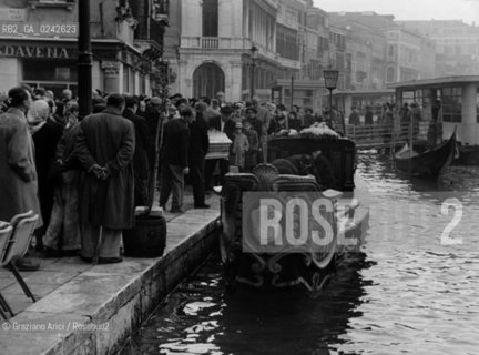 -Venezia,anni 50.Rialto. Barca funeraria barca dei morti .Trasporto di una bara sulla barca in Canal Grande nei pressi del ponte di Rialto. Venezia Geo funerale bara barca funerario morto.-Venice, 50 Years. The funerary boat near the Rialtòs Bridge in Grand Canal, during the transport of a coffin - Archivio Graziano Arici.LArchivio Arici non è riuscito ad avere informazioni sullautore di questa foto. Siamo comunque a disposizione di qualunque avente diritto per riconoscere eventuali proprietà intellettuali che non sia stato possibile fin qui attribuire. .Qualora si fosse inavvertitamente leso qualsiasi diritto di riproduzione, si prega di contattare lArchivio che provvederà a rimuovere le immagini in questione..La cessione dei diritti di questa immagine si intende per quanto di nostra competenza. Non comprende invece le eventuali spese  relative a diritti che potranno essere richiesti dagli Enti o persone fisiche cui appartengono eventualmente i soggetti  ripresi. Tali costi, ove necessari, e l’espletamento di qualsivoglia pratica di richiesta di concessione del permesso di pubblicazione sono esclusivamente a carico e a cura del soggetto acquirente di questa immagine..