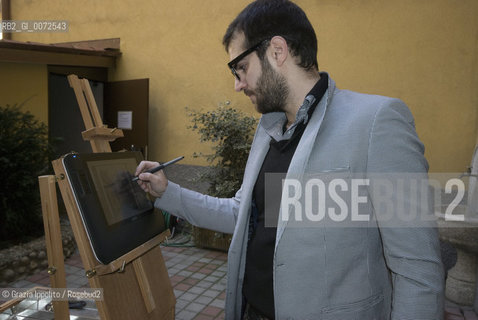 Emiliano Ponzi, illustrator winner of numerous awards,contributor of The New York Times, Le Monde, La Repubblica, Il Corriere della Sera, draws with electronic pen on the computer set on a traditional tripod ©Grazia Ippolito/Rosebud2