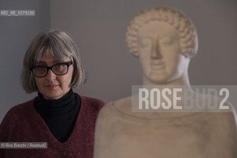 Rome April 11, 2019..Carola Susani, writer, photographed in Rome in the spaces of the Museum of Classical Art of the La Sapienza University, in front of the bust of the 6th century. B.C. coming from Medma/Carola Susani, scrittrice, fotografata a Roma negli spazi del Museo di Arte Classica dellUniversità La Sapienza, davanti al busto del VI sec. a.C. proveniente da Medma. ©Rino Bianchi/Rosebud2