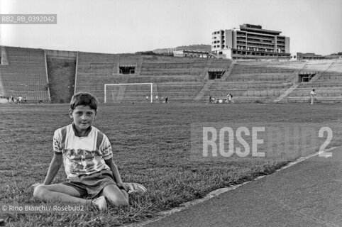 Sarajevo September 1994..A very young athlete rests on the edge of the athletics track of the Sarajevo stadium/Un giovanissimo atleta si riposa ai bordi della pista di atletica dello stadio di Sarajevo. ©Rino Bianchi/Rosebud2