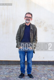 Biella, September 11, 2026..Guido Catalano, an Italian poet and writer who writes for *Il Corriere della Sera Torino* and *Torino Sette* (part of *La Stampa*) and collaborates with *Smemoranda*, photographed in Biella in front of the former De Agostini factory during the Fuoriluogo Festival/Guido Catalano poeta e scrittore italiano, scrive per Il Corriere della Sera Torino, Torino Sette de La Stampa e collabora con Smemoranda, fotografato a Biella davanti lex Opificio De Agostini durante il Festival Fuoriluogo. ©Rino Bianchi/Rosebud2