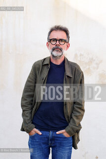 Biella, September 11, 2026..Guido Catalano, an Italian poet and writer who writes for *Il Corriere della Sera Torino* and *Torino Sette* (part of *La Stampa*) and collaborates with *Smemoranda*, photographed in Biella in front of the former De Agostini factory during the Fuoriluogo Festival/Guido Catalano poeta e scrittore italiano, scrive per Il Corriere della Sera Torino, Torino Sette de La Stampa e collabora con Smemoranda, fotografato a Biella davanti lex Opificio De Agostini durante il Festival Fuoriluogo. ©Rino Bianchi/Rosebud2
