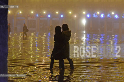 Due ragazze passeggiano nellacqua alta in piazza San Marco, nelle prime ore di oggi, 25 dicembre 2010. Alle due di stamattina la marea si è attestata sui 130 cm sul medio mare: una leggera nebbia nel frattempo è calata in laguna, sostituendosi alla pioggia battente dei giorni scorsi. ©Andrea Merola/Rosebud2