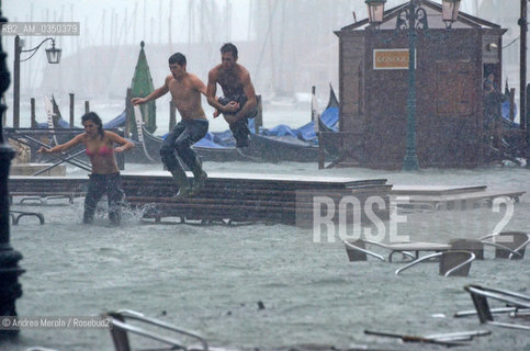 Tre ragazzi si tuffano nellacqua alta che stamane, 11 novembre 2012, ha allagato piazza San Marco, e il 70% del centro storico, raggiungendo il picco alle ore 9 e 25 con 149 cm sul medio mare. ©Andrea Merola/Rosebud2