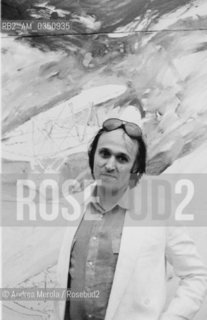 Mario Schifano, pittore, posa accanto una sua opera, alla Biennale Arte di Venezia, giugno 1982..Italian painter Mario Schifano poses next his work, at Biennale Modern Art Exhibition, june 1982 Venice.. ©Andrea Merola/Rosebud2