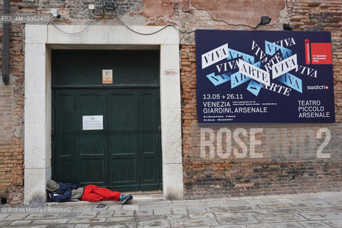 Un senzatetto dorme sdraiato a terra vicino lingresso delle Corderie dellArsenale, campo dellArsenale, 57° Biennale Arte, Venezia 9 maggio 2017..Homeless sleeps lied on street floor, close Arsenale gate entrance, Arsenale square, 57°th Biennale Arte, may 09, Venice 2017. ©Andrea Merola/Rosebud2