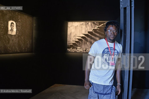 Lartista del Mozambico Màrio Macilau posa accanto ad una sua opera fotografica, esposta nel padiglione della Santa Sede, allArsenale, durante Biennale Arte 56°, Venezia 7 maggio 2015. © ANDREA MEROLA.The Mozambican artist Màrio Macilau poses next to one of his photographic works, exhibited in the Pavilion of the Holy See, at the Arsenal, during the 56th Art Biennale, Venice 7 May 2015.  ©Andrea Merola/Rosebud2