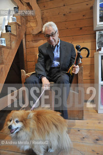 Il maestro della fotografia del 900 Elliott Erwitt posa seduto in un angolo allinterno della galleria Casa dei Tre Oci, in Giudecca a Venezia, durante la vernice della mostra Personal Best dedicata alla sua carriera fotografica, Venezia 29 marzo 2012. © ANDREA MEROLA.The master of 20th century photography Elliott Erwitt poses sitting in a corner inside the Casa dei Tre Oci gallery, in Giudecca in Venice, during the painting of the exhibition Personal Best dedicated to his photographic career, Venice March 29th, 2012.  ©Andrea Merola/Rosebud2