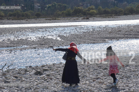 Due donne passeggiano sulle sponde del fiume Piave, in località Isola dei Morti..LIsola dei Morti è una insenatura del fiume Piave, dal fondale basso e ghiaioso, dove frequentemente si arenavano i cadaveri dei soldati, trascinati dalla corrente..Il paese di Moriago, ribatezzato Moriago della Battaglia, nel 1918 si trovò nel mezzo del cosidetto fronte del Piave, tra lesercito italiano posizionato sulle colline del Montello, e lesercito austriaco a valle, il fiume e il centro abitato come terra di nessuno. Gli abitanti sfollarono per la maggior parte, anche se alcuni rimasero a custodia delle case, che però vennero in gran parte distrutte dai bombardamenti di entrambi gli schieramenti..Finita la Grande Guerra, la popolazione di Moriago fu insignita dellonoreficenza della Medaglia dOro al Valore Civile. © Andrea MEROLA  .Two women walk on the banks of the Piave river, in Isola dei Morti..The Island of the Dead is an inlet of the Piave river, with a shallow, gravelly bottom, where the corpses of soldiers, frequently dragged by the current, ran aground..The town of Moriago, renamed Moriago della Battaglia, in 1918 found itself in the middle of the so-called front of the Piave, between the Italian army positioned on the hills of Montello, and the Austrian army downstream, the river and the inhabited center as a land of nobody. The inhabitants displaced for the most part, although some remained in custody of the houses, which however were largely destroyed by the bombing of both sides..After the Great War, the population of Moriago was awarded the honor of the Gold Medal to Civil Value.  ©Andrea Merola/Rosebud2