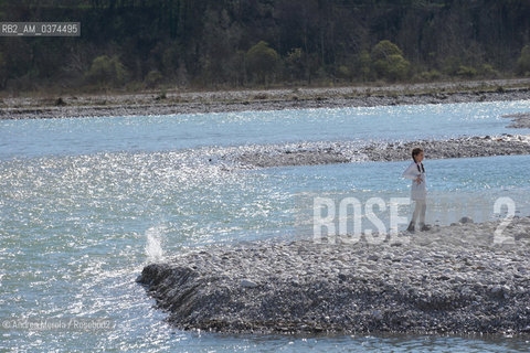 Una bambina si diverte a lanciare sassi nel fiume Piave, in località Isola dei Morti..LIsola dei Morti è una insenatura del fiume Piave, dal fondale basso e ghiaioso, dove frequentemente si arenavano i cadaveri dei soldati, trascinati dalla corrente..Il paese di Moriago, ribatezzato Moriago della Battaglia, nel 1918 si trovò nel mezzo del cosidetto fronte del Piave, tra lesercito italiano posizionato sulle colline del Montello, e lesercito austriaco a valle, il fiume e il centro abitato come terra di nessuno. Gli abitanti sfollarono per la maggior parte, anche se alcuni rimasero a custodia delle case, che però vennero in gran parte distrutte dai bombardamenti di entrambi gli schieramenti..Finita la Grande Guerra, la popolazione di Moriago fu insignita dellonoreficenza della Medaglia dOro al Valore Civile. © Andrea MEROLA  .A little girl likes to throw rocks in the Piave river, in Isola dei Morti..The Island of the Dead is an inlet of the Piave river, with a shallow, gravelly bottom, where the corpses of soldiers, frequently dragged by the current, ran aground..The town of Moriago, renamed Moriago della Battaglia, in 1918 found itself in the middle of the so-called front of the Piave, between the Italian army positioned on the hills of Montello, and the Austrian army downstream, the river and the inhabited center as a land of nobody. The inhabitants displaced for the most part, although some remained in custody of the houses, which however were largely destroyed by the bombing of both sides..After the Great War, the population of Moriago was awarded the honor of the Gold Medal to Civil Value.  ©Andrea Merola/Rosebud2