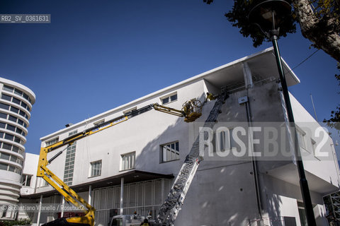 Lido di Venezia, 21 Agosto 2017. Lavori di allestimento del Palazzo del Cinema per la 74a edizione della Mostra Internazionale del Cinema di Venezia. Due operai fissano dei cavi elettrici allesterno del palazzo del Cinema. ©Sebastiano Vianello/Rosebud2