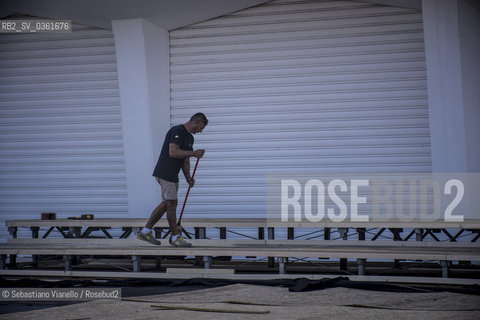 Lido di Venezia, 21 Agosto 2017. Lavori di allestimento del Palazzo del Cinema per la 74a edizione della Mostra Internazionale del Cinema di Venezia.Un addetto spazza il praticabile in costruzione che ospiterà i fotografi per il red carpet della Mostra del Cinema. ©Sebastiano Vianello/Rosebud2