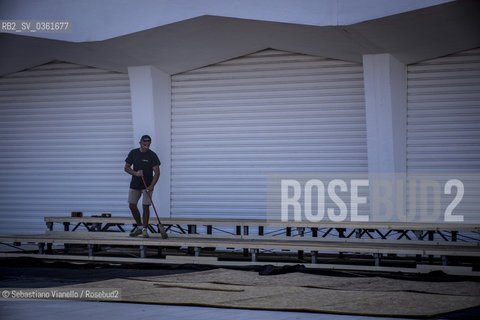 Lido di Venezia, 21 Agosto 2017. Lavori di allestimento del Palazzo del Cinema per la 74a edizione della Mostra Internazionale del Cinema di Venezia.Un addetto spazza il praticabile in costruzione che ospiterà i fotografi per il red carpet della Mostra del Cinema. ©Sebastiano Vianello/Rosebud2